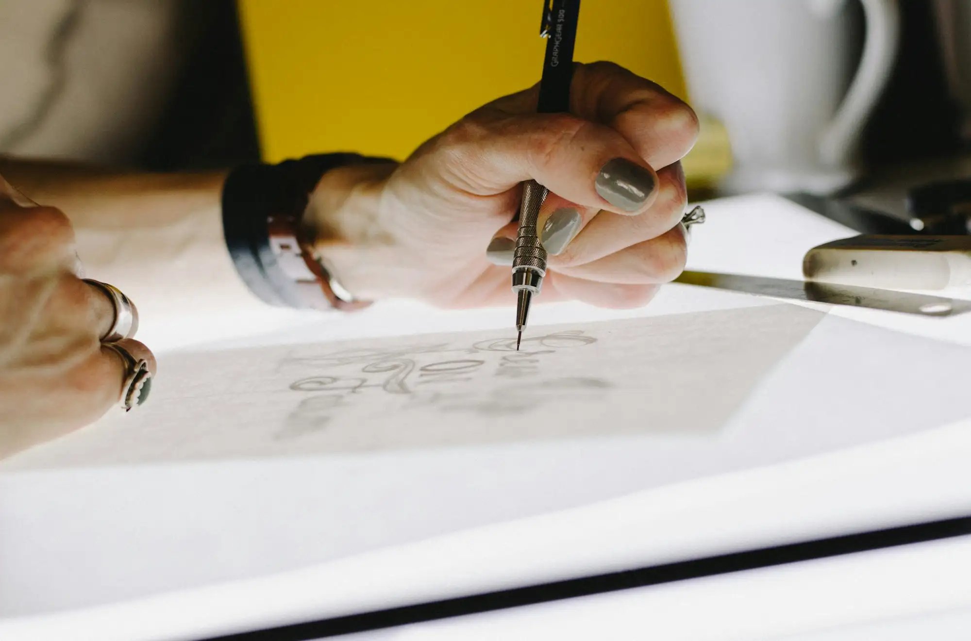 A hand lettering on tracing paper with a mechanical pencil