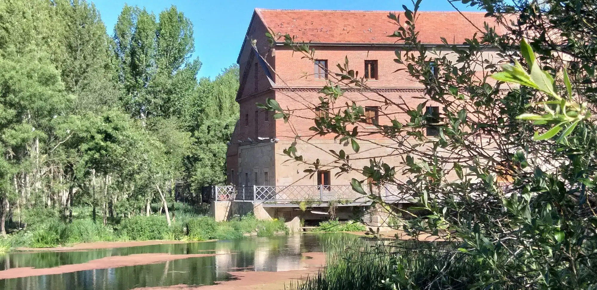 A brick mill building beside the water
