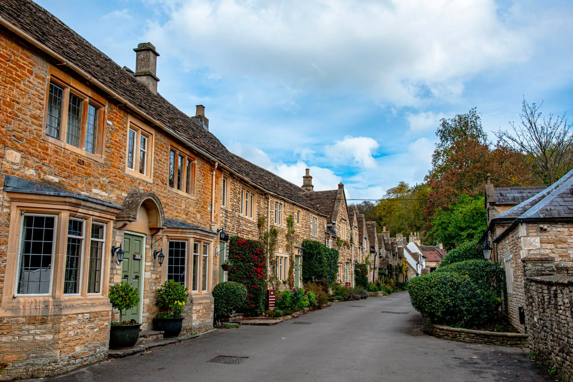 A village street of stone buildings and trees
