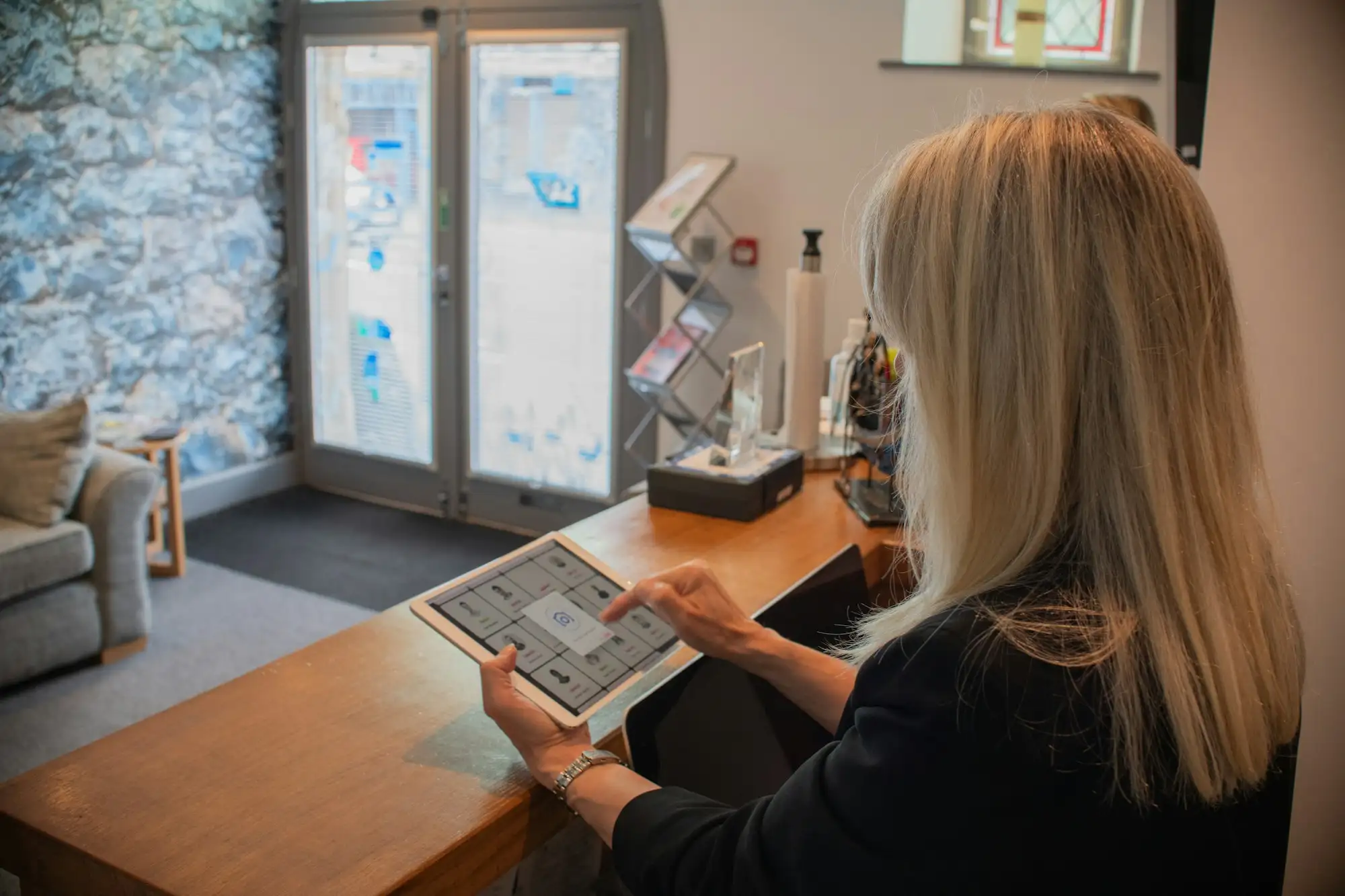 A woman using a tablet at a reception desk