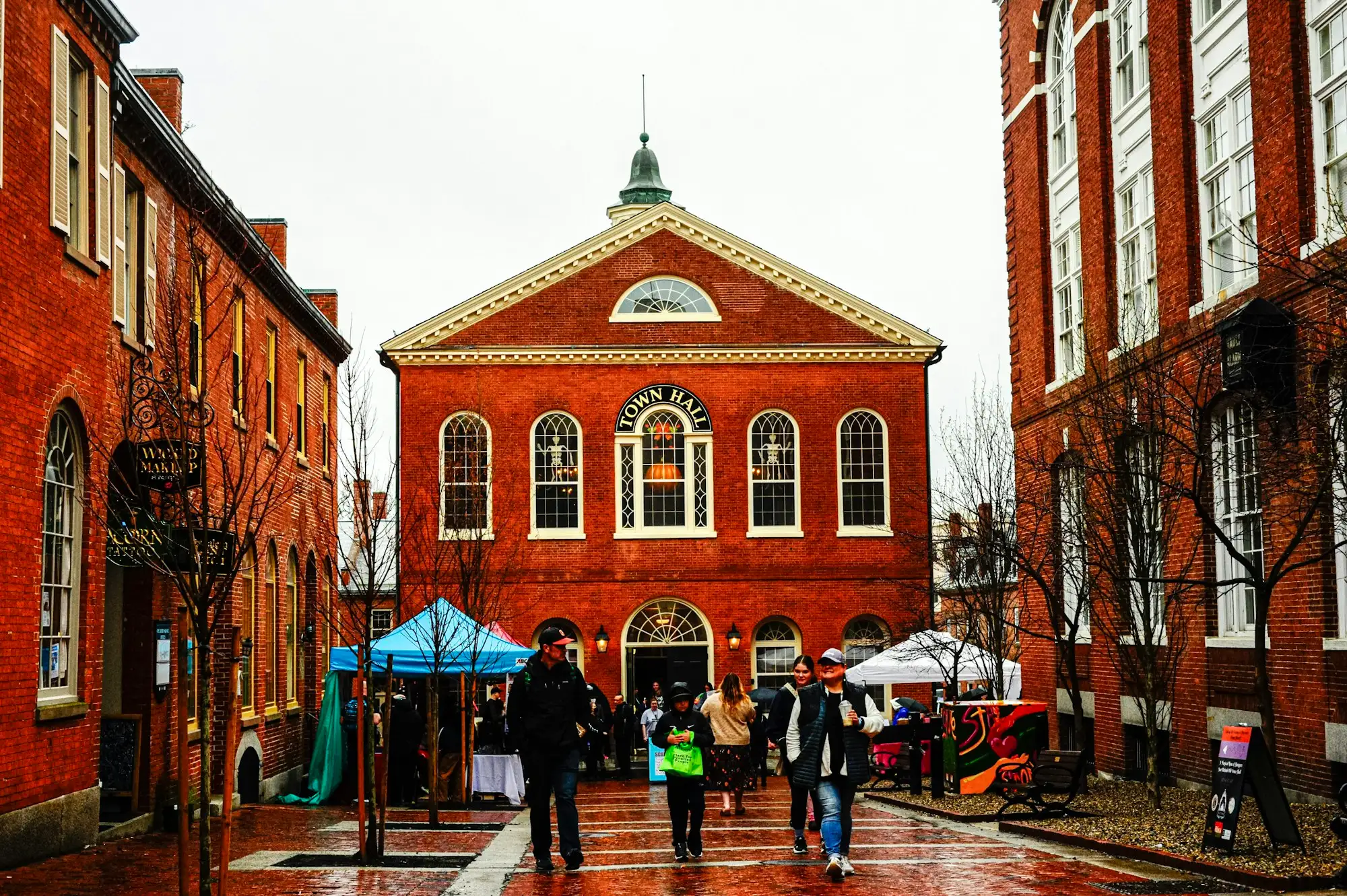 People walking past a red-brick town hall